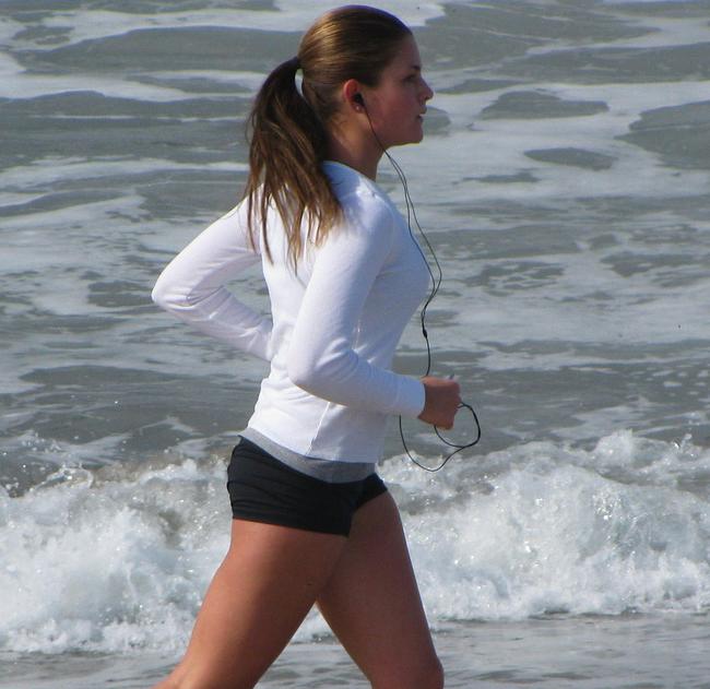 mulher correndo praia cuidados com a pele